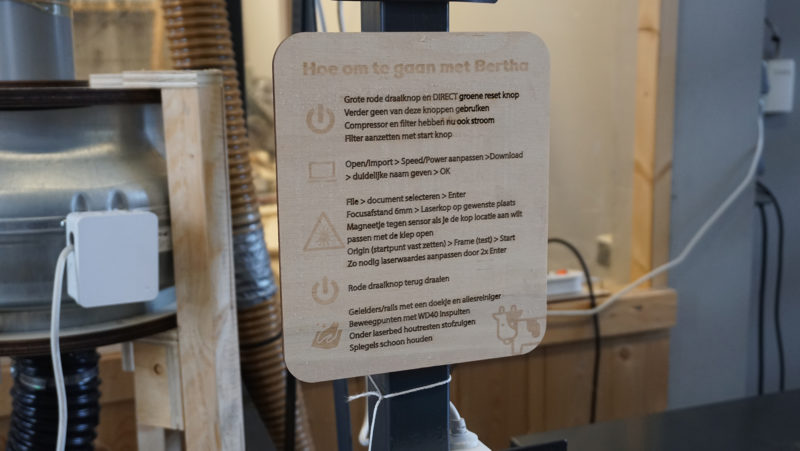 A wooden sign made with the laser. Contains instructions on how to use the machine.