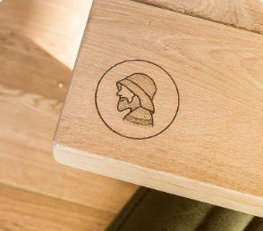 A logo engraved on a wooden tabletop in a restaurant.