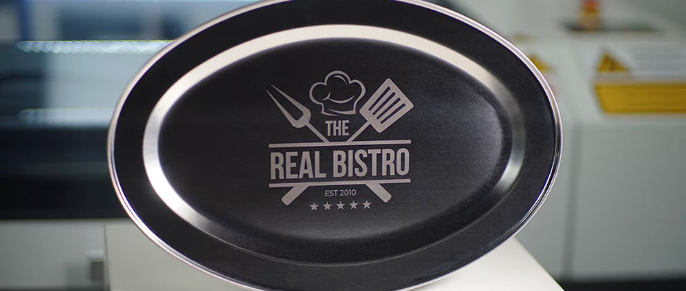 An engraving of a restaurant's logo on a stainless steel plate.