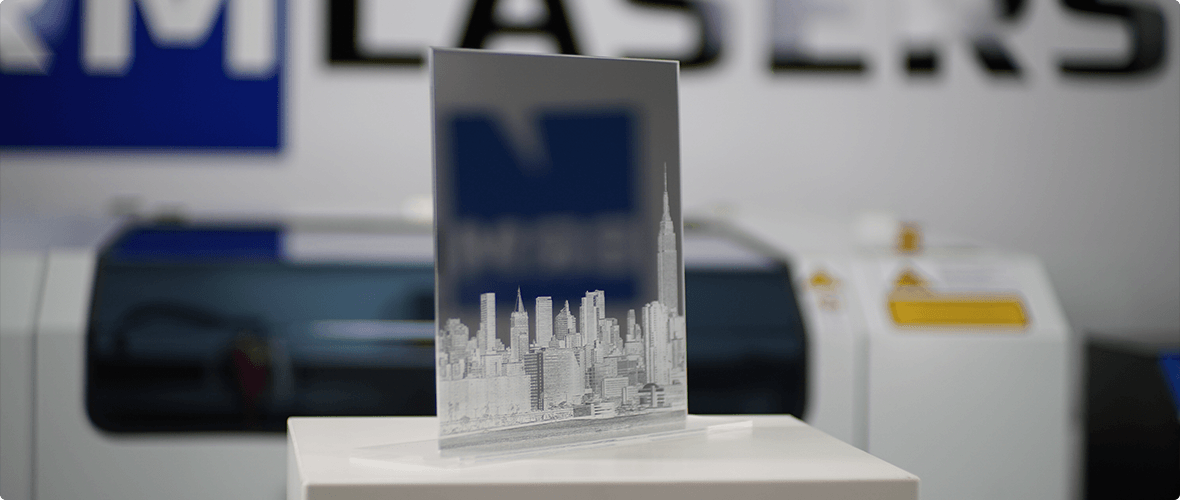 Een door de lasermachine gegraveerde spiegel met de afbeelding van een skyline.