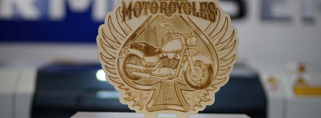 Wooden sign with an engraved logo of a motorcycle store.